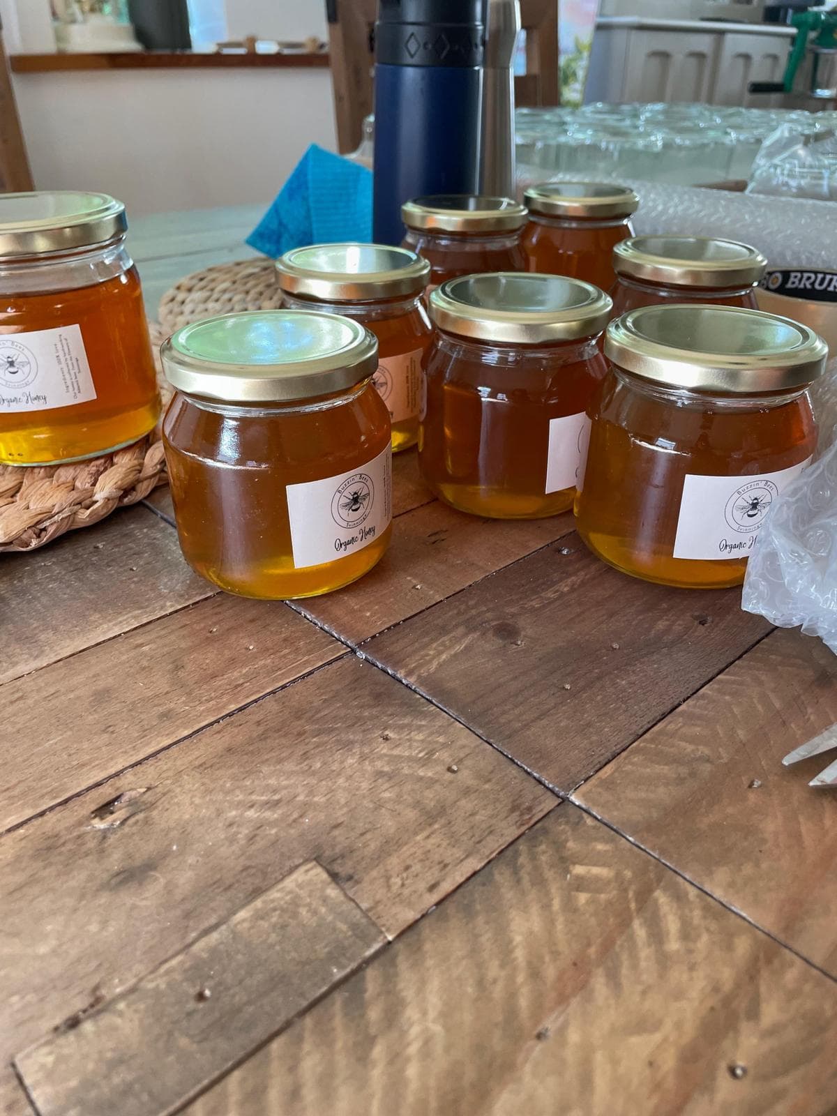 Buzzin' Bees honey jars on a wooden table